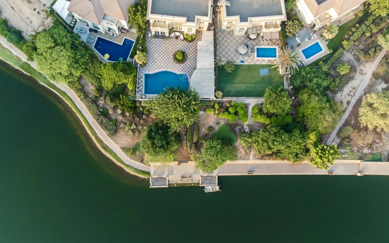 Aerial view of a villa with a pool beside a lake