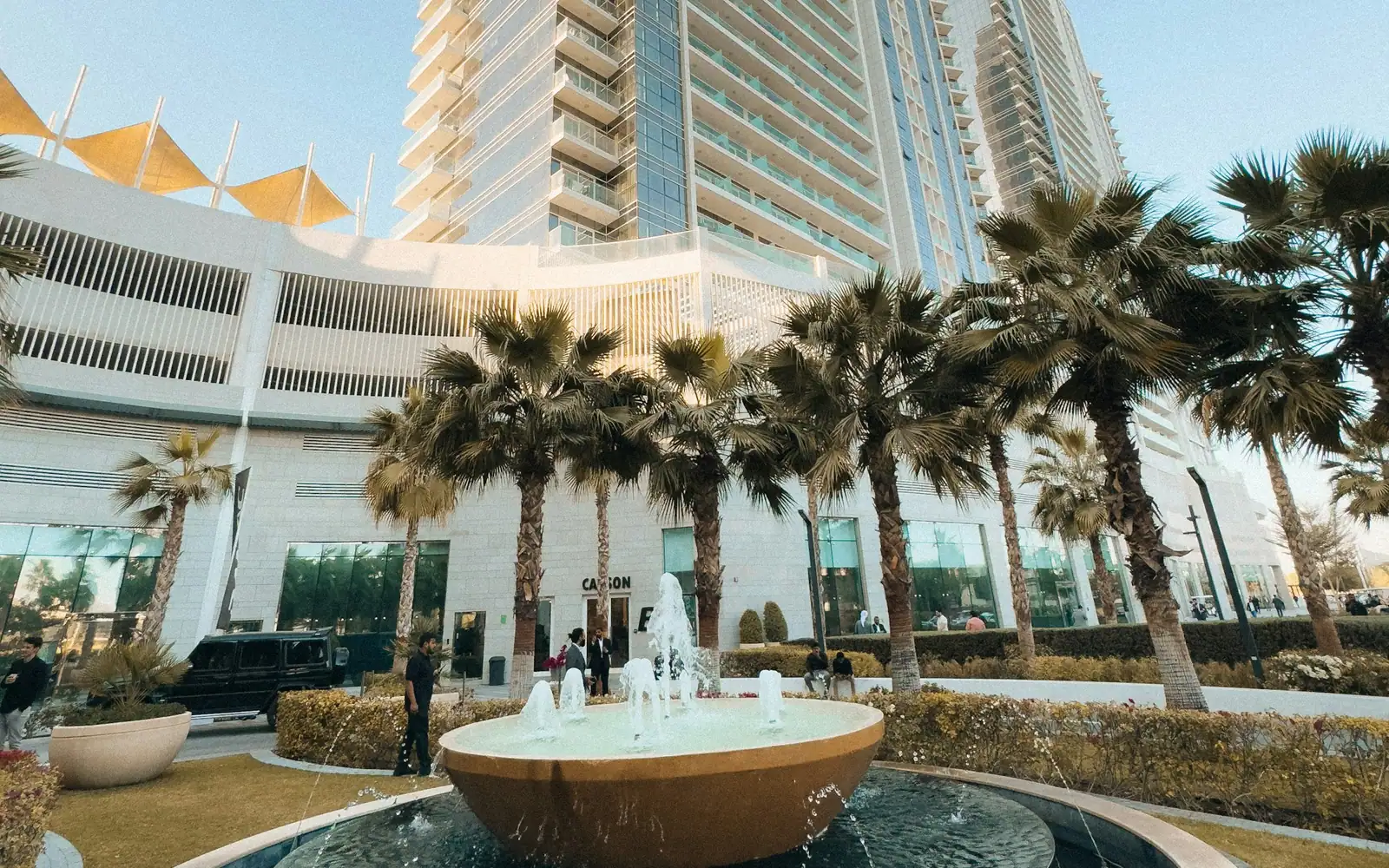 Modern residential building with a fountain and palm trees