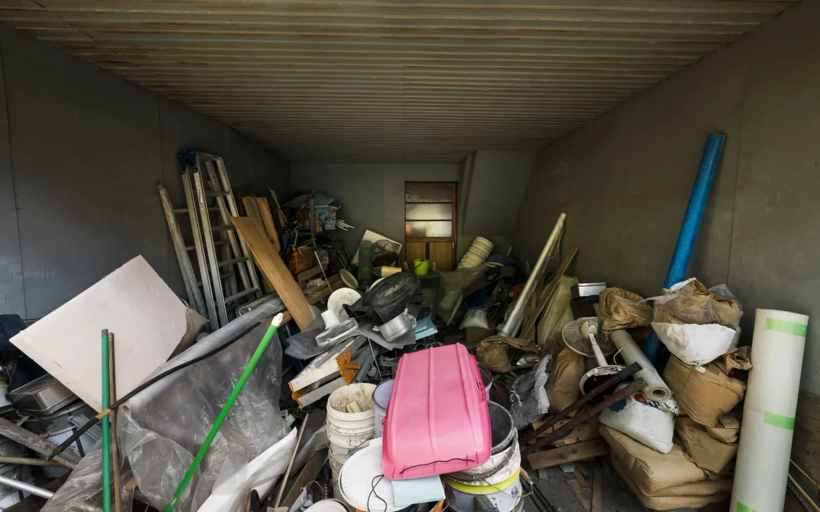 Room packed with boxes, old furniture and clutter, the kind of job that sets the junk removal cost in Dubai